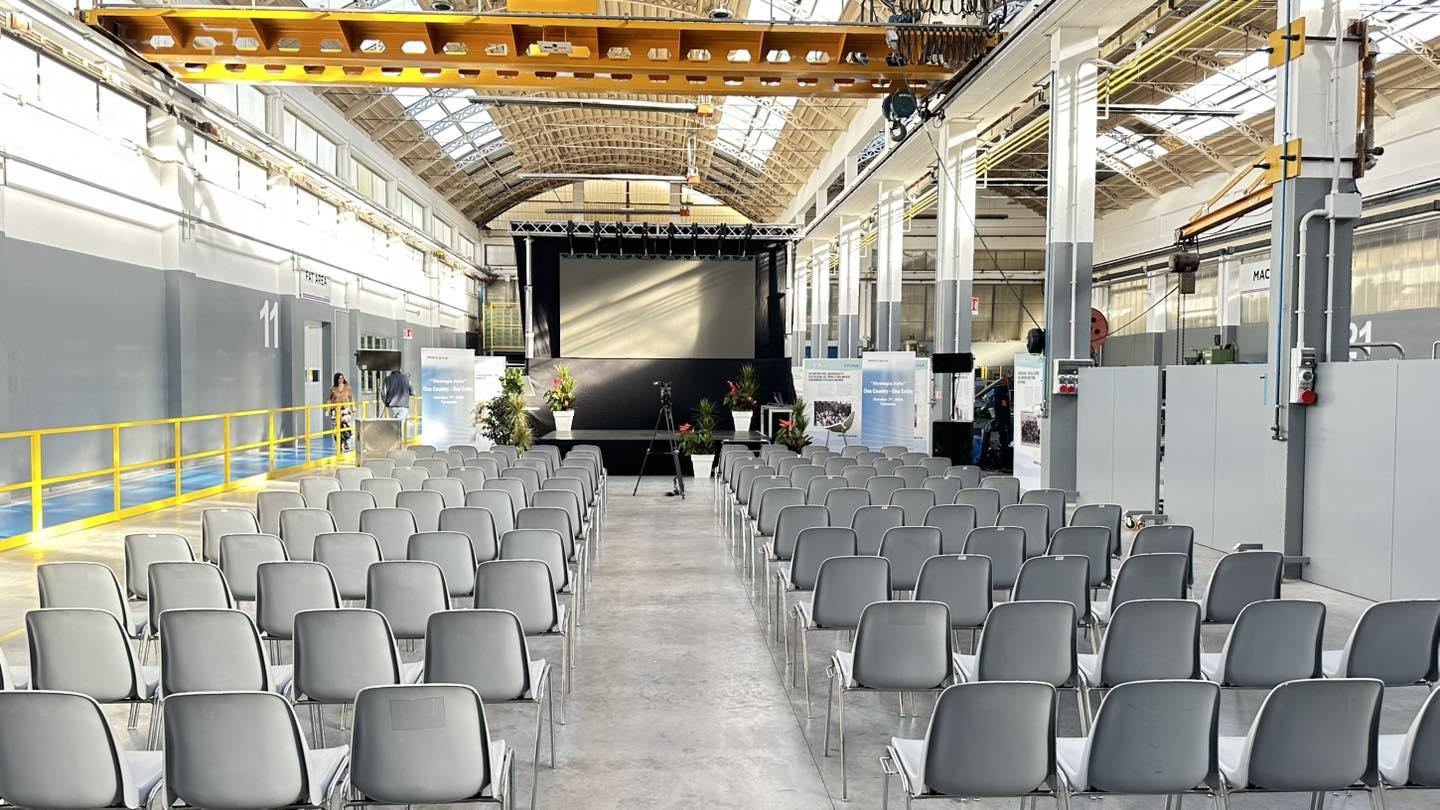Convention aziendale: palco, schermo e platea in capannone